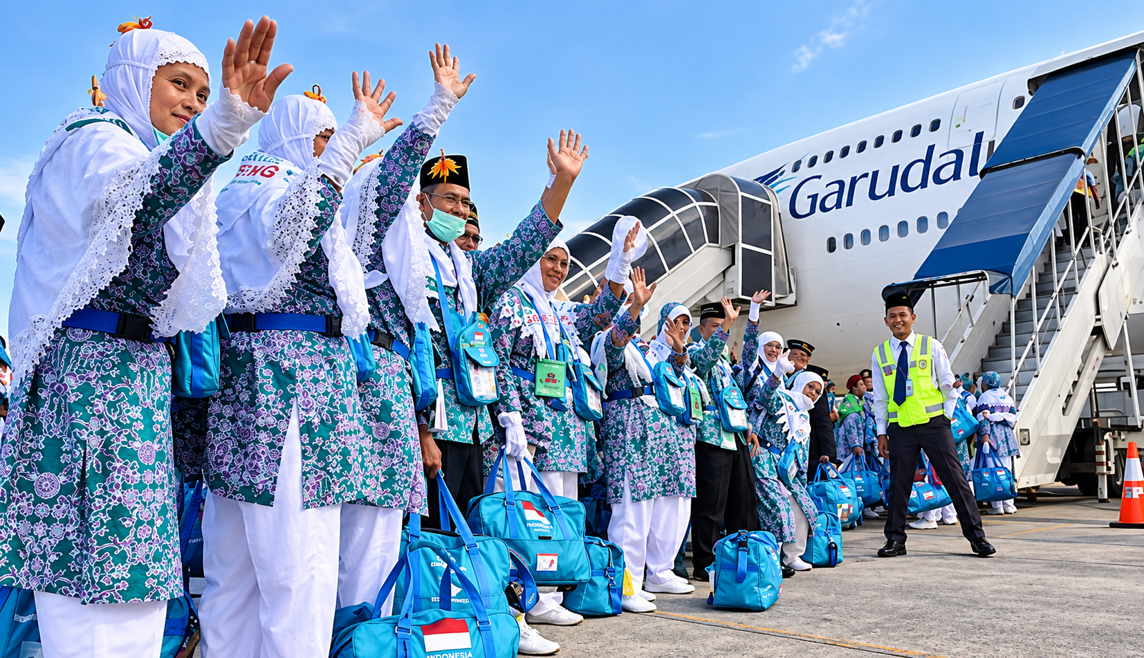 Indonesian Pilgrims Wave Beside Garuda Aircraft.png